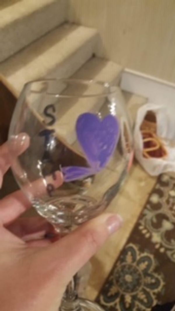 A hand painted wine glass with a purple heart